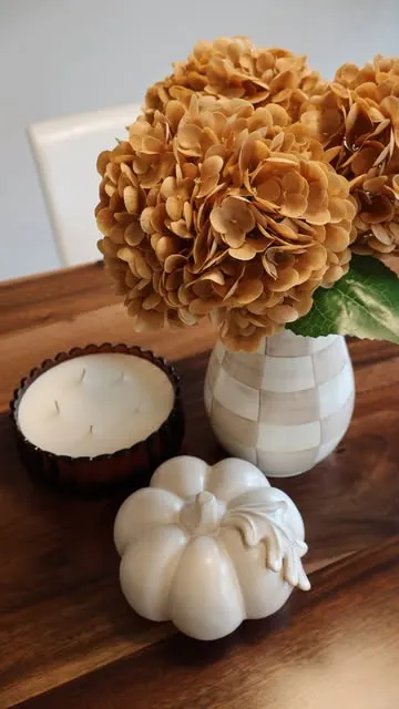 Autumn table styling with dried hydrangeas, a candle and ceramic pumpkins